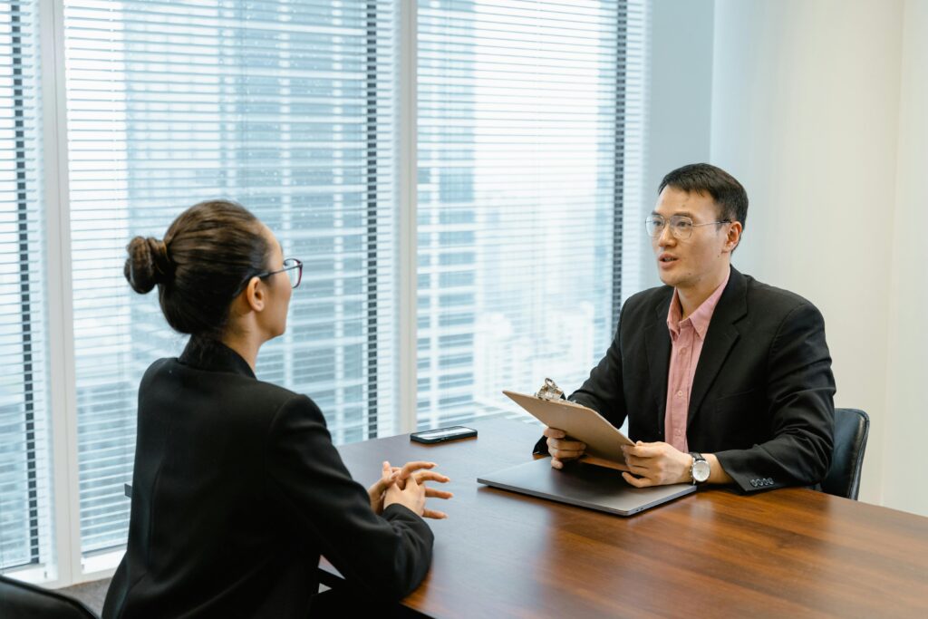 Professional business meeting in a modern office with two people discussing over documents.